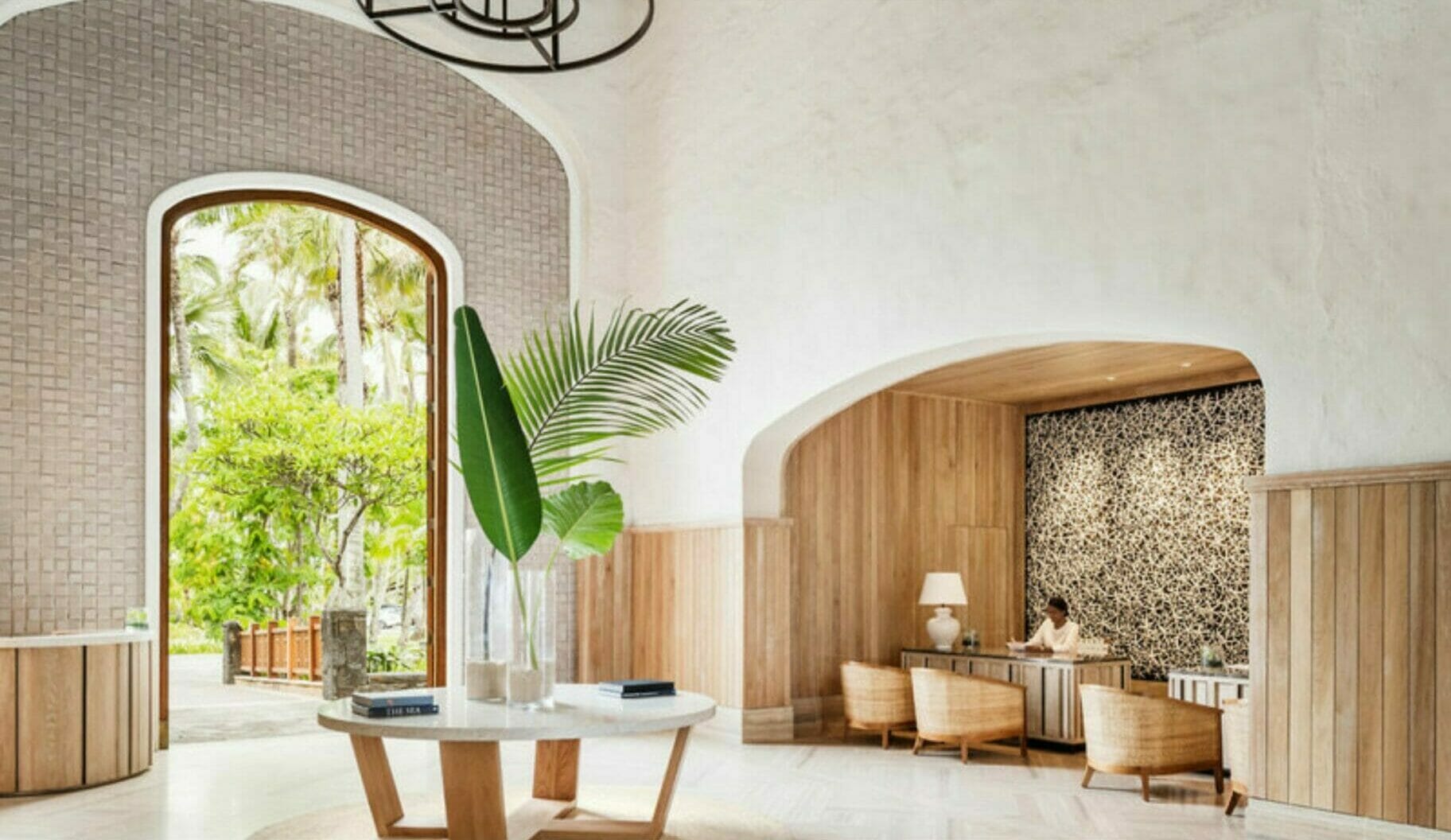 Die Lobby eines Hotels ist mit Holz und Pflanzen dekoriert.